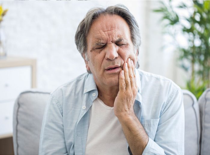 Person in Pain Before having a Wisdom Teeth Removal Treatment In Quincy and Norwell, MA