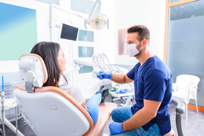 A Young Male Dentist Treating a Female Patient in a Dental Chair